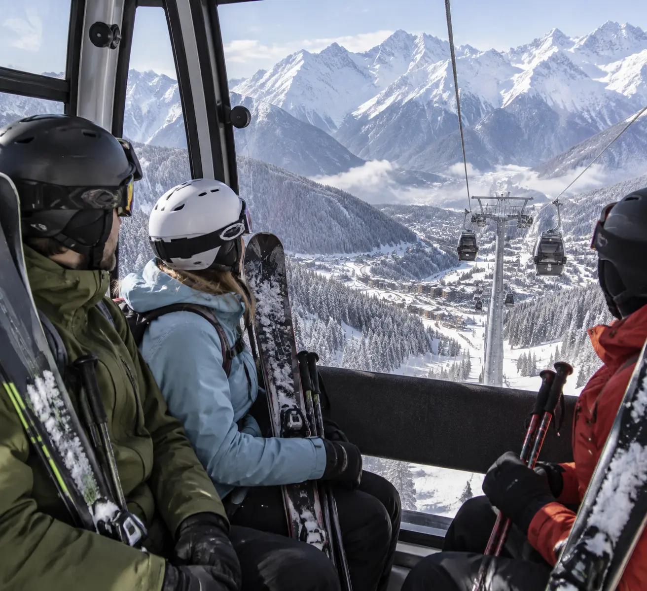 Канатная дорога на Красной Поляне зимой: лыжники с прокатным снаряжением поднимаются к верхней станции курорта на фоне заснеженных хребтов